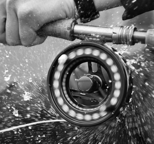 fly fisherman holding fly rod and reel