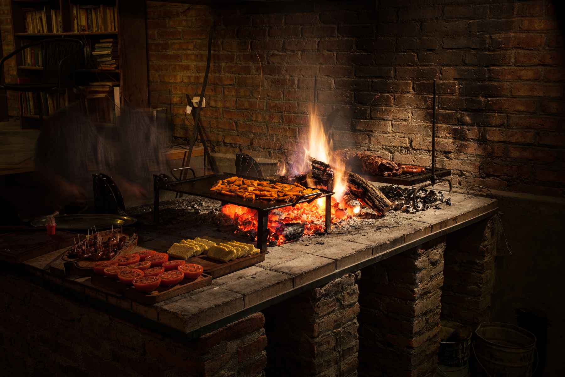 Tending to the fire, where tomatoes, cornbread, sausages and beef are grilled for a welcoming feast at Estancia Huechahue (photo: Chad Shmukler). Patagonia - Estancia Huechahue