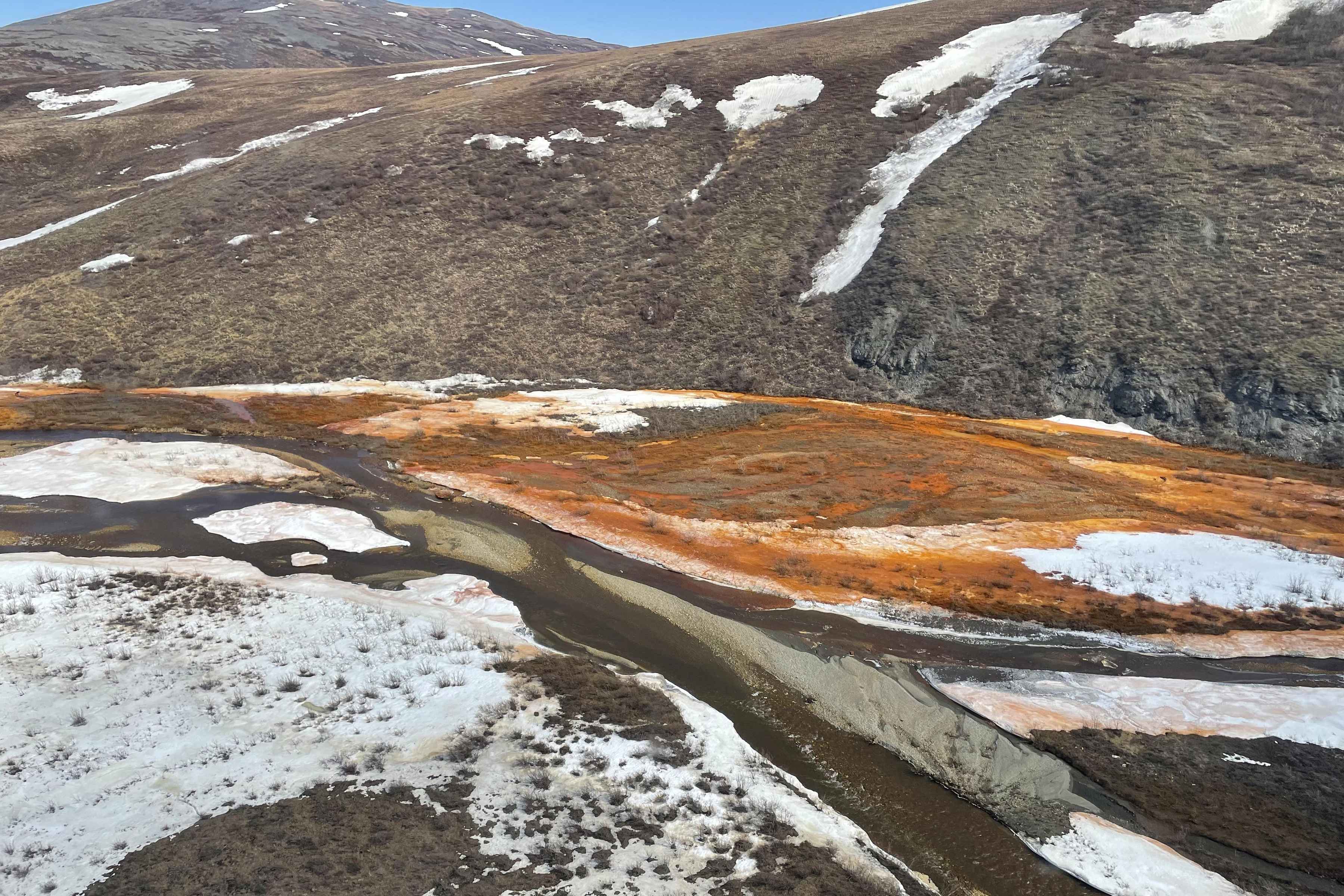 Orange water and snow in a braidplain of the Nakolikruk River