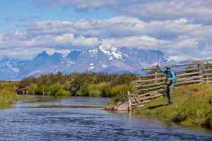 The famed Torres del Paine massif looms in the distance while an angler casts to a rising brown trout (photo: Earl Harper). torres del paine region fly fishing