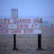 no lifeguards sign on beach