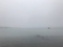 boats and fog and clouds on the lake