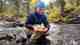 The author, Erica Zazo, lands a brook trout on Glacier Creek outside of Rocky Mountain National Park