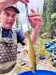 Alex Burks, a CPW aquatic technician, weighs an adult greenback cutthroat trout during a recent CPW survey of Herman Gulch west of Denver